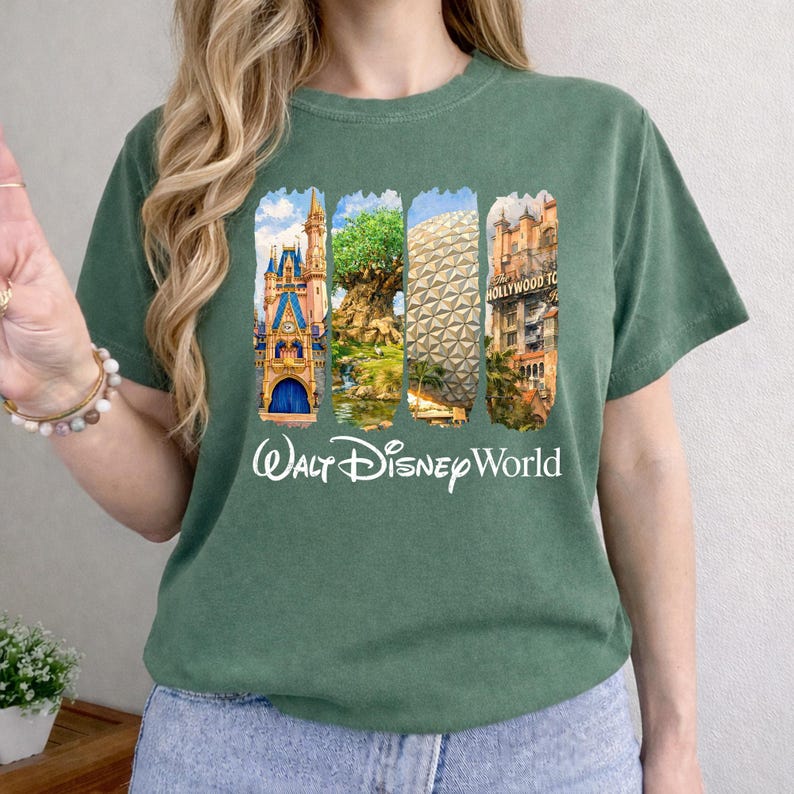 Puede incluir: Camiseta verde con un gr&aacute;fico colorido que muestra los lugares emblem&aacute;ticos de Walt Disney World. El dise&ntilde;o incluye el castillo de Cenicienta, el &Aacute;rbol de la Vida, Spaceship Earth y el Hollywood Tower Hotel. Las palabras "Walt Disney World" est&aacute;n impresas en blanco debajo.