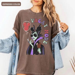 May include: A white ceramic mug with a black handle and the text "But First, Coffee" in a handwritten style. The mug is on a white surface. The mug is approximately 4 inches tall.