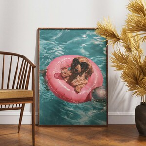 May include: A rectangular wall art print featuring a long-haired dachshund wearing black heart-shaped sunglasses, floating in a bright pink circular pool tube on turquoise water while holding a clear glass of white wine in its front paw.