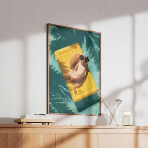 May include: A rectangular wall art print featuring a brown squirrel wearing black sunglasses while lying on a bright yellow inflatable pool float. The scene is set against a teal water background with dark palm leaf shadows cast across the surface.