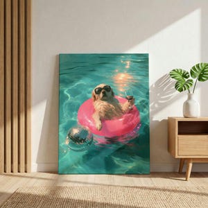 May include: A rectangular wall art print depicting a golden-colored dog wearing black sunglasses, floating in a bright pink circular pool tube within turquoise water. The dog holds a clear glass of red wine, and a silver disco ball floats nearby.