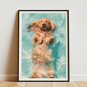 May include: A framed wall art print featuring a golden-colored dog floating on its back in bright turquoise water. The dog has its eyes closed and paws tucked near its chest, with visible ripples and light reflections on the water surface.