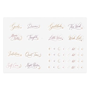 May include: A sheet of stickers with gold and purple script. The stickers include words like "Goals," "Dreams," "Gratitude," and "This Week." Additional stickers feature celestial designs such as stars, moons, and planets. The stickers are designed for journaling and planning.