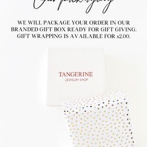 May include: White gift box with the text "TANGERINE JEWELRY SHOP" in red. A second gift box is wrapped in white paper with gold polka dots. The text "Our packaging" is written in cursive.