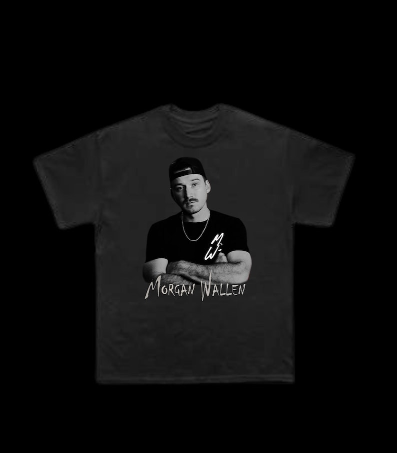 K&ouml;nnte beinhalten: Schwarzes T-Shirt mit einem Schwarz-Wei&szlig;-Bild eines Mannes mit Baseballkappe und Halskette. Der Text "Morgan Wallen" ist darunter in wei&szlig;er Schrift gedruckt. Das T-Shirt hat einen Rundhalsausschnitt.