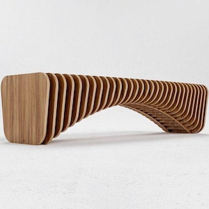 May include: A bench constructed from a series of vertical, light brown wooden slats arranged in a repeating, curved pattern. The structure features a continuous, undulating form with a hollow space underneath the central arch of the seat.