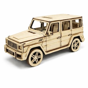以下が含まれることがあります： 明るい色の木製スポーツユーティリティビークル（SUV）のモデル。モデルには、ホイール、窓、サンルーフなどの詳細な機能があります。 SUVは明るい茶色で、白い表面にあります。