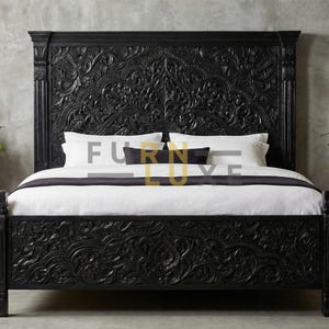 Puede incluir: Una cama de madera negra con intrincados diseños florales tallados en la cabecera y el pie de cama. La cama está hecha con ropa de cama blanca y almohadas oscuras. La imagen incluye el texto "FURN LUXE".