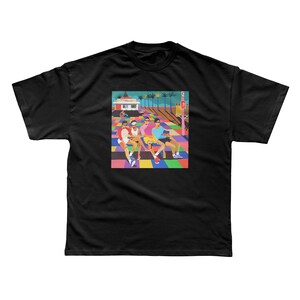以下が含まれることがあります： カラフルなグラフィックプリントが施された黒いTシャツ。グラフィックは、背景に建物とヤシの木がある、カラフルな横断歩道にいる人々のグループを描いています。横断歩道は幾何学模様です。