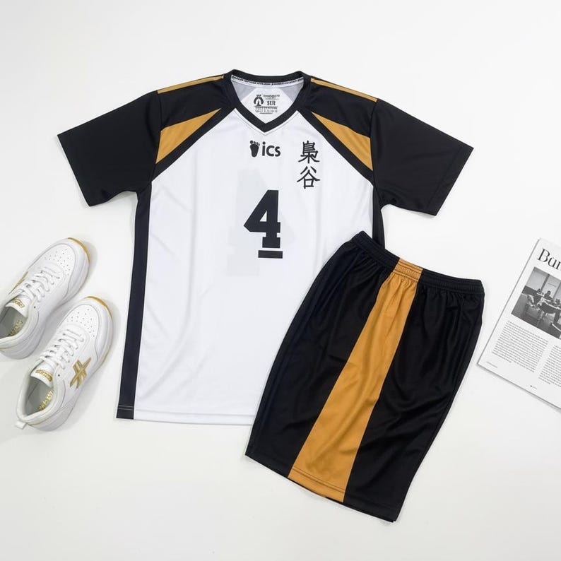 May include: A white and black volleyball jersey with the number 4, paired with black shorts with a gold stripe. White sneakers with gold accents are also in the image. The jersey has Japanese text.
