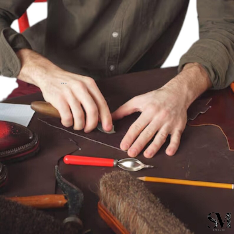 May include: A shoemaker's workshop with tools and materials. The image shows a person working on leather, using a knife and other tools. A partially finished shoe is visible, along with brushes, pencils, and other crafting supplies.