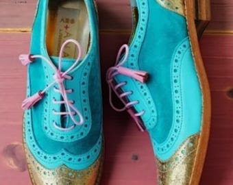 Handgemaakte damesschoenen in blauw en goud met vleugelneus en vetersluiting.