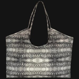 Puede incluir: Un bolso tote grande con un estampado de piel de serpiente en tonos grises y blancos. El bolso tiene dos correas largas para llevar al hombro. El bolso está hecho de un material duradero y es adecuado para el uso diario.