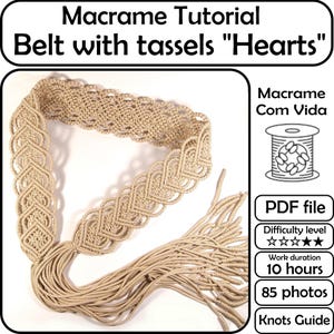 Può includere: Una cintura in macramè beige con un design a forma di cuore e lunghe nappe. La cintura è fatta a mano e presenta intricati motivi di nodi. L'immagine include anche il testo "Macrame Tutorial Belt with tassels Hearts".