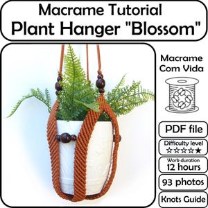Peut inclure: Un porte-plante en macramé marron, tenant un pot en céramique blanc avec du feuillage vert. Le porte-plante a des perles en bois et est suspendu à une corde marron. Le texte "Macrame Tutorial Plant Hanger Blossom" est en haut.
