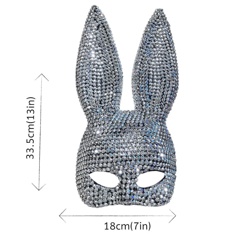 May include: A silver bunny mask covered in sparkling rhinestones. The mask measures 13 inches (33.5cm) in height and 7 inches (18cm) in width. The mask has eye openings and long, upright ears, perfect for a costume or party.