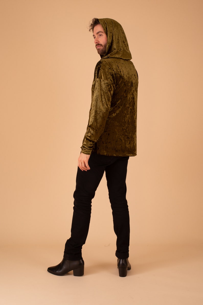 Op de afbeelding: Een groene gekreukelde fluwelen hoodie met lange mouwen. De hoodie wordt gedragen door een persoon met een baard en is gefotografeerd vanaf de achterkant.