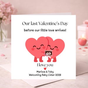 May include: A square greeting card with a white background featuring two smiling pink heart characters holding an ultrasound image. The text reads: Our last Valentine's Day before our little love arrives! I love you, Marissa & Toby Welcoming Baby Lister 2026.