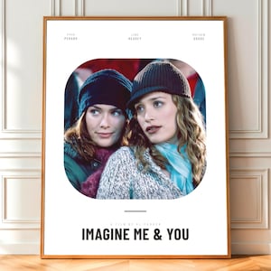 Könnte beinhalten: Gerahmtes Filmplakat für "Imagine Me & You" mit zwei Frauen in einer Umarmung. Der Hintergrund ist weiß, mit dem Titel und den Credits unten. Die Frauen tragen Hüte und Schals.