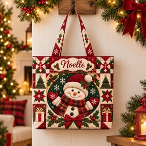 Può includere: Una borsa tote trapuntata con un pupazzo di neve centrale che indossa un cappello e una sciarpa rossi, circondato da un bordo patchwork di alberi di Natale, stelle di Natale e regali. Il nome Noelle è ricamato in rosso su un banner bianco.
