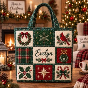 May include: A quilted tote bag featuring a patchwork design with Christmas motifs including a wreath, snowflake, cardinal, plaid pattern, ornament, holly, star, and candy canes. The center square displays the name Evelyn in cursive script.