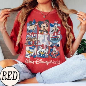 May include: Red t-shirt featuring a grid of Disney characters in patriotic attire. Mickey and Minnie Mouse, Donald and Daisy Duck, Goofy, Chip and Dale, and Stitch are depicted. The text "Walt Disney World" is printed below the grid.