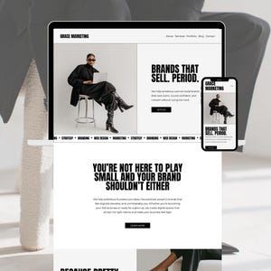 Könnte beinhalten: Ein Laptop und ein Smartphone zeigen eine Website mit dem Text "GRACE MARKETING" und "BRANDS THAT SELL. PERIOD." Die Website zeigt eine Person in schwarzer Kleidung und den Text "YOU'RE NOT HERE TO PLAY SMALL AND YOUR BRAND SHOULDN'T EITHER."
