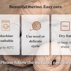 Op de afbeelding: Vier bollen garen in beige en grijstinten met een overlay van tekst en iconen. De tekst luidt: Beautiful merino. Easy care. Machine washable up to 40&deg;C. Use wool or delicate cycle. Dry flat to keep its shape. Please follow the included care card.