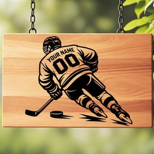 May include: A rectangular wooden sign featuring a black graphic of a hockey player in motion. The player wears a jersey with the text "YOUR NAME" and the number "00" on the back. The player holds a hockey stick near a puck on the wood surface.