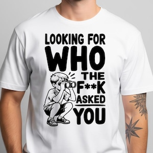 May include: White t-shirt with a black graphic. The graphic features the text "LOOKING FOR WHO THE F*** ASKED YOU" and an illustration of a child looking through binoculars. The shirt is a crew neck.