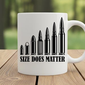 May include: White ceramic mug featuring a black graphic of bullets increasing in size. The text "SIZE DOES MATTER" is printed below the bullets. The mug is on a wooden surface.