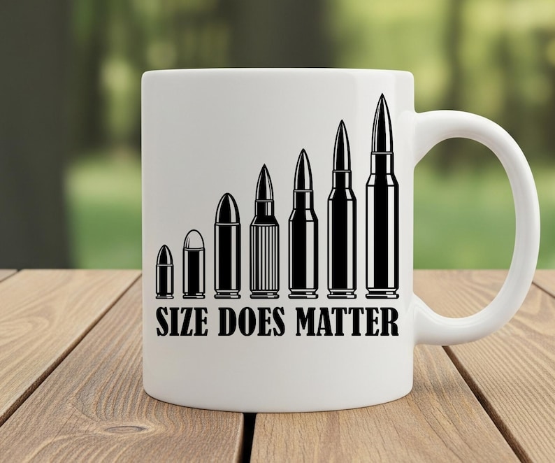 May include: White ceramic mug featuring a black graphic of bullets increasing in size. The text "SIZE DOES MATTER" is printed below the bullets. The mug is on a wooden surface.