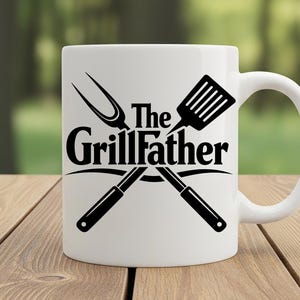 以下が含まれることがあります： 「The GrillFather」の黒い文字と、交差したグリルツールが描かれた白いセラミックマグ。 デザインにはヘラとフォークが含まれています。 マグカップは湾曲したハンドルが付いています。