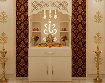 May include: A white wooden temple with a decorative cutout design, featuring a deity statue, shelves, and floral arrangements. The temple is set against a patterned red and gold backdrop, with gold accents and a marble floor.
