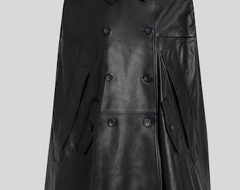 May include: A black leather cape with a double-breasted front, featuring large buttons and a classic collar. The cape has two front pockets and shoulder epaulettes. The garment is a stylish outerwear piece.