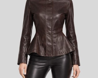 May include: A brown leather jacket with a peplum waist and a high collar. The jacket has a zipper closure and long sleeves. The model is wearing black leather pants.