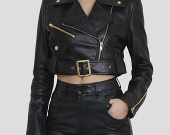 May include: Black leather cropped motorcycle jacket with gold-tone hardware, including zippers, buttons, and a buckle belt. The jacket features a classic asymmetrical design with a notched collar and long sleeves.