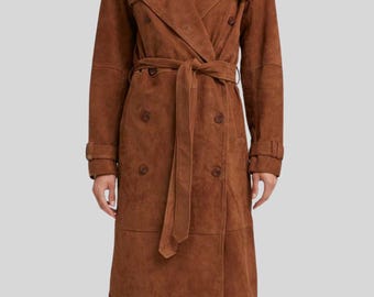 Puede incluir: Un abrigo trench de ante marrón con diseño cruzado, cinturón y detalles de botones. El abrigo tiene un estilo clásico de gabardina con cuello con muescas y mangas largas. El abrigo mide aproximadamente 140 cm de largo.