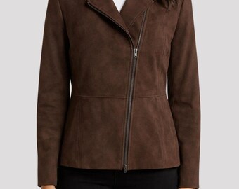 May include: A brown suede jacket with an asymmetrical zipper closure. The jacket has a notched collar and long sleeves. The jacket is a solid color and appears to be made of a soft material. The model is wearing a white shirt underneath and black pants.