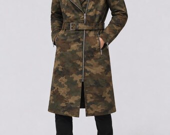 May include: A long camouflage trench coat featuring a notched lapel, an asymmetrical silver-tone zipper closure, and a matching waist belt with a buckle. The coat includes zippered pockets and zippered cuffs, paired with black trousers and black boots.