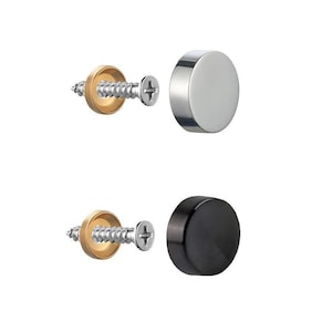 May include: Two sets of hardware components. One set includes a silver-colored, circular cap and a screw with a brass-colored washer. The other set features a black, circular cap and a screw with a brass-colored washer.
