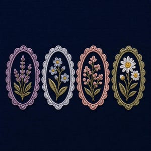 Puede incluir: Cuatro diseños florales bordados en marcos ovalados. Cada marco tiene un borde festoneado y presenta una flor diferente: lavanda, margaritas y otras flores delicadas. El bordado es en tonos de rosa, blanco y dorado sobre un fondo azul marino.