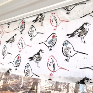 May include: White fabric with a repeating pattern of sketched birds in black, gray, and red. The birds are in various poses, some with red eye details. The fabric is likely used for curtains or a similar window treatment.