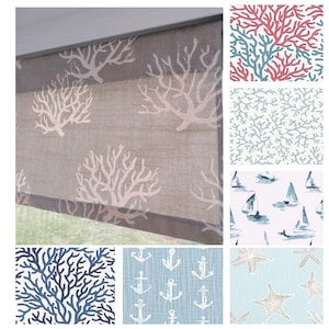 May include: A window shade with a gray background and a white coral pattern. The image also shows various fabric swatches with nautical themes, including coral, sailboats, anchors, and starfish in shades of blue, white, and coral.