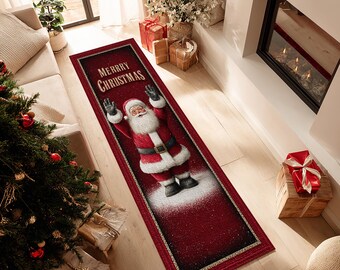 Op de afbeelding: Een rechthoekig rood kerstkleed met de kerstman en de tekst "MERRY CHRISTMAS". Het kleed heeft een gouden rand en ligt op een houten vloer. De afmetingen van het kleed zijn in centimeters.