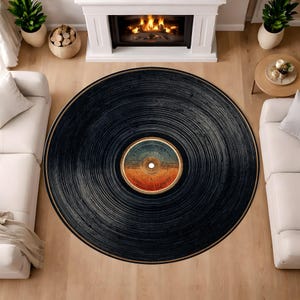 May include: A round rug designed to resemble a vintage vinyl record. The rug is primarily black with concentric grooves and a central label featuring orange, blue, and tan hues. The rug's design evokes a retro aesthetic, suitable for living rooms or music-themed spaces.