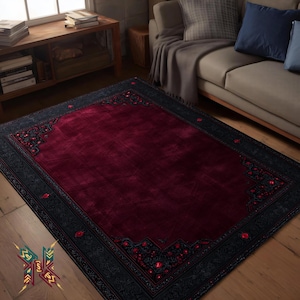 Puede incluir: Una alfombra rectangular con un centro burdeos oscuro y un borde gris oscuro. El borde presenta intrincados patrones florales con acentos rojos. La alfombra está colocada sobre un suelo de madera, con un sofá y una mesa auxiliar en el fondo.