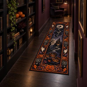 Op de afbeelding: Een lange rechthoekige loper met een donker Halloween-ontwerp, voorzien van een centraal spookkasteel, een volle maan met een heksensilhouet, vliegende vleermuizen en meerdere gloeiende oranje pompoenen omringd door spinnenwebben en bladeren.