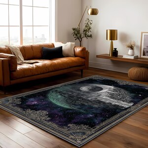 May include: Rectangular area rug featuring a detailed image of the Death Star from Star Wars set against a cosmic background of purple, blue, and green hues. The rug has a decorative border with gold accents, suitable for a living room.