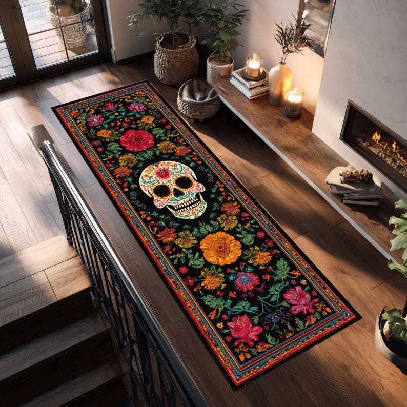 May include: A long, rectangular black rug with a Day of the Dead skull design. The rug is decorated with colorful flowers in shades of red, orange, yellow, and pink. The rug is placed on a wooden floor.